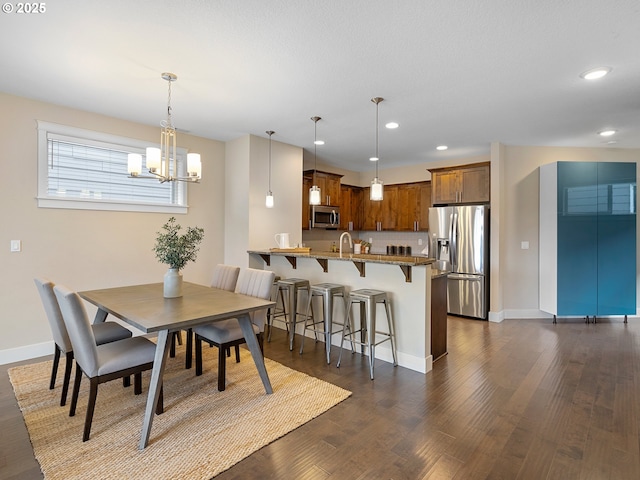 dining room featuring recessed lighting, baseboards, dark wood-type flooring, and an inviting chandelier