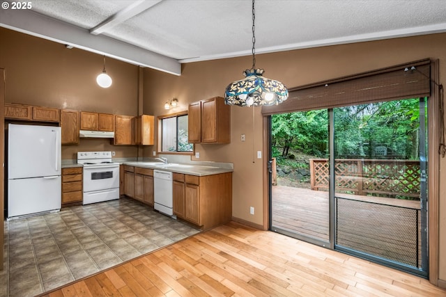 761 Foothill Dr, Eugene, OR 97405 - kitchen with white appliances, under cabinet range hood, brown cabinets, light countertops, and a textured ceiling
