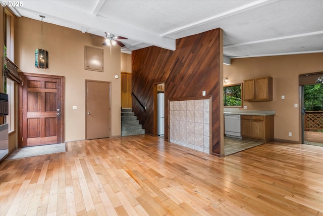 761 Foothill Dr, Eugene, OR 97405 - unfurnished living room featuring light wood-type flooring, stairway, ceiling fan, wood walls, and a textured ceiling