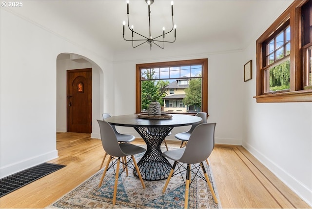 4004 N Montana Ave, Portland, OR 97227 - dining space with a chandelier, arched walkways, and light wood-type flooring