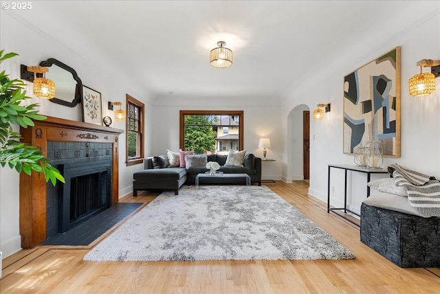 4004 N Montana Ave, Portland, OR 97227 - living area with arched walkways, a fireplace with flush hearth, and wood finished floors