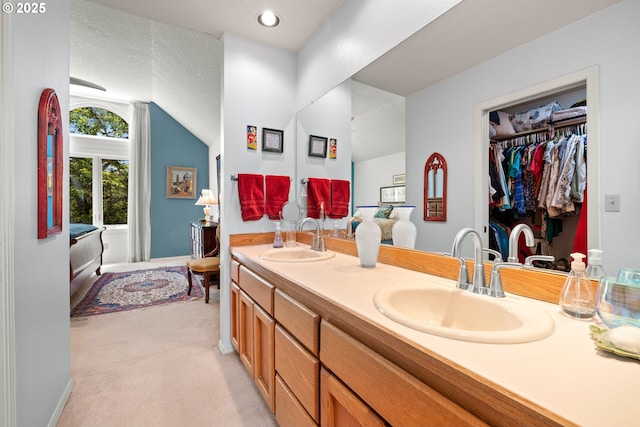 16165 NW Blueridge Dr, Beaverton, OR 97006 - full bathroom featuring double vanity, vaulted ceiling, and a walk in closet