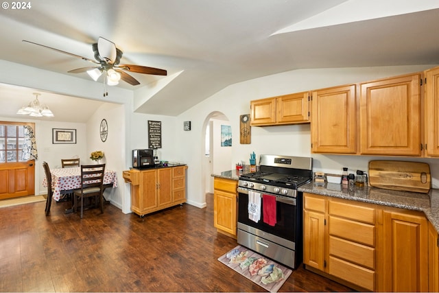 kitchen featuring stainless steel range with gas cooktop, dark hardwood / wood-style flooring, dark stone countertops, vaulted ceiling, and ceiling fan with notable chandelier