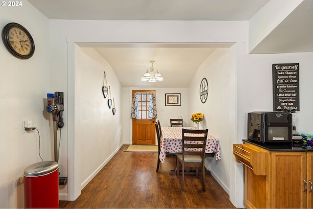 dining area with dark hardwood / wood-style flooring and a chandelier