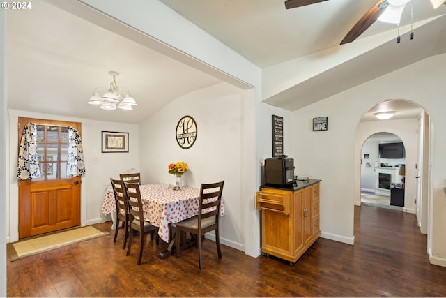 dining room with vaulted ceiling, dark hardwood / wood-style flooring, and ceiling fan with notable chandelier