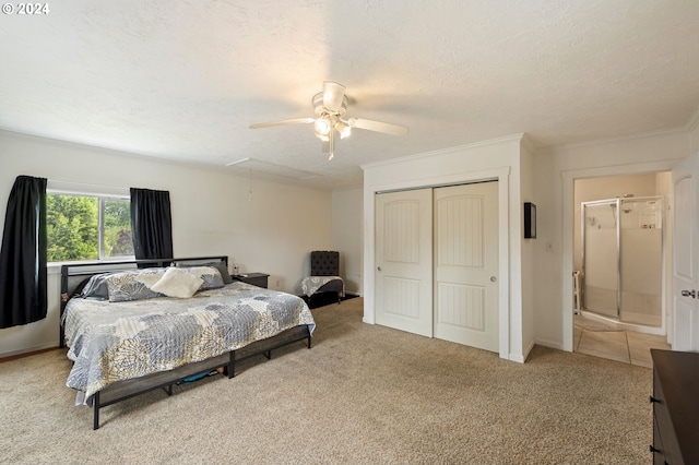 bedroom featuring light carpet, ceiling fan, a closet, and a textured ceiling