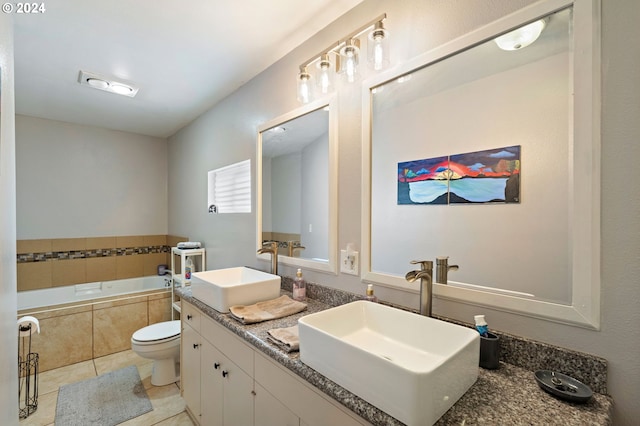 bathroom featuring toilet, tile patterned flooring, tiled tub, and vanity