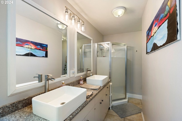 bathroom with a shower with shower door, vanity, and tile patterned flooring