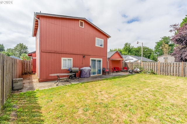 rear view of property with a lawn and a patio