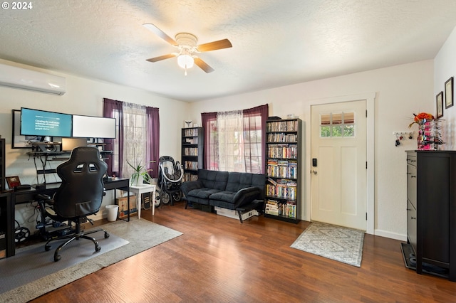 office space with ceiling fan, a textured ceiling, dark hardwood / wood-style floors, and a wall unit AC