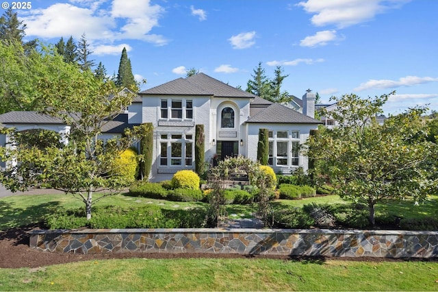 view of front of home with stucco siding and a chimney