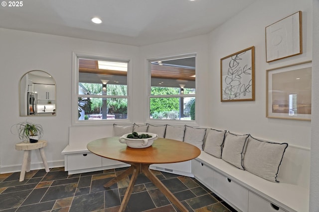 dining room with breakfast area, dark stone finish flooring, baseboards, and recessed lighting