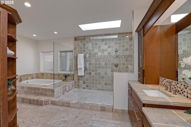 full bathroom featuring a skylight, a garden tub, a walk in shower, vanity, and recessed lighting
