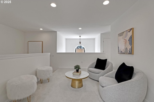 sitting room with carpet floors, recessed lighting, and an upstairs landing