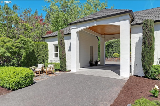 view of patio featuring asphalt driveway and a carport