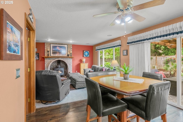 180 NE 29th Dr, Gresham, OR 97030 - dining room with wood-type flooring, ceiling fan, a wood stove, and a textured ceiling