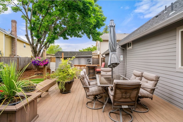180 NE 29th Dr, Gresham, OR 97030 - wooden deck featuring outdoor dining area, a fenced backyard, and an outbuilding