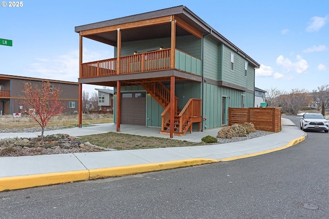 modern home with an attached garage, stairway, and board and batten siding