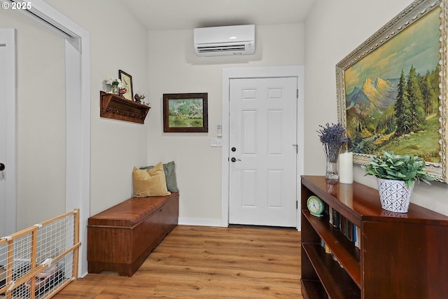 entrance foyer featuring a wall unit AC and light wood-style floors