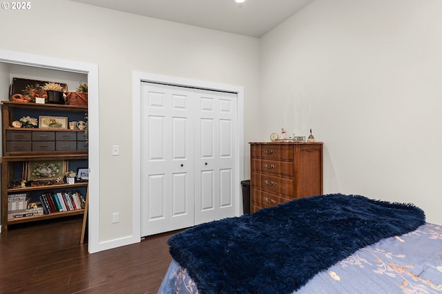 bedroom featuring dark wood-style flooring, a closet, and baseboards