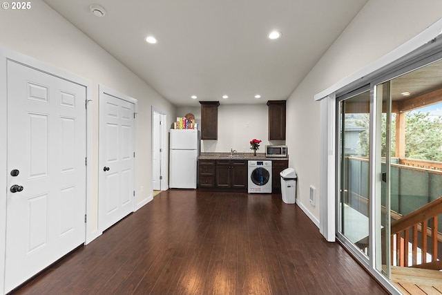 kitchen featuring dark brown cabinetry, washer / dryer, stainless steel microwave, freestanding refrigerator, and light countertops