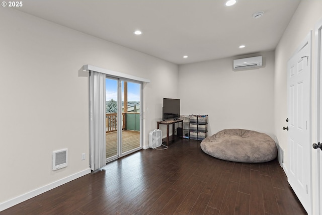 living area with baseboards, an AC wall unit, dark wood-type flooring, and recessed lighting