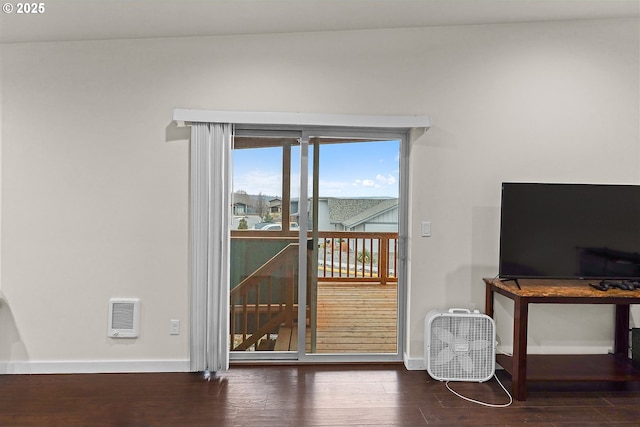 interior space featuring dark wood-type flooring, heating unit, and baseboards