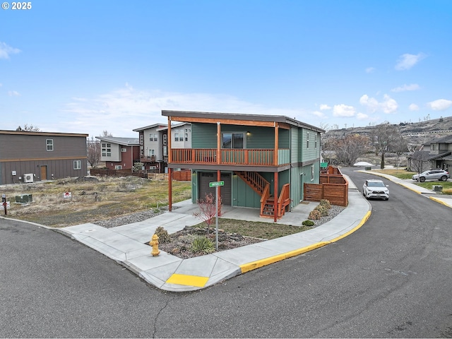 view of front of home with a deck, stairway, and a residential view