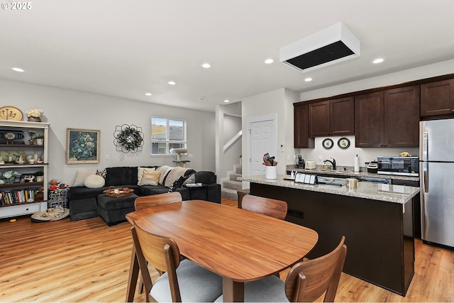 dining space featuring light wood-style flooring, stairs, and recessed lighting