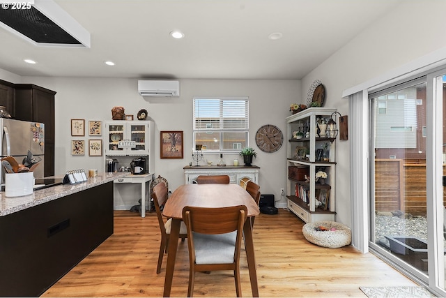 dining room featuring light wood-type flooring, an AC wall unit, and recessed lighting