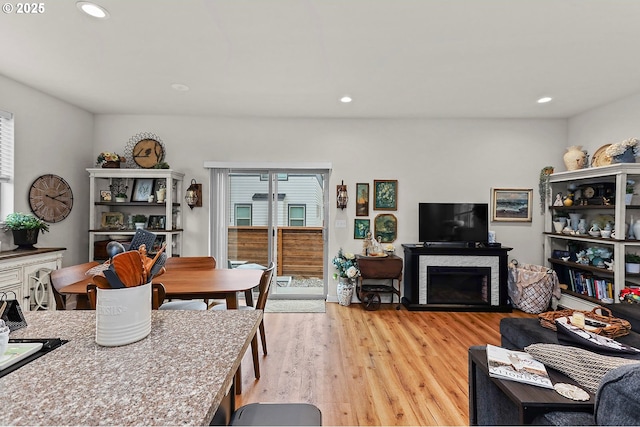 interior space featuring light wood-style flooring, a fireplace, and recessed lighting