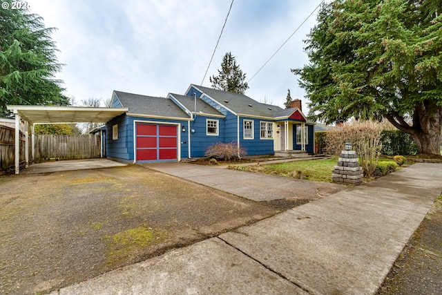 view of front of home featuring a carport, driveway, a chimney, and fence