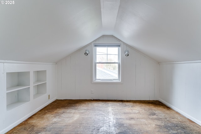 additional living space with built in features and vaulted ceiling