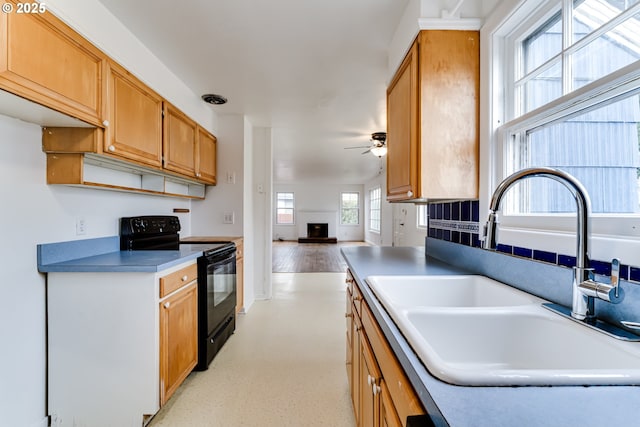 kitchen featuring a sink, a ceiling fan, open floor plan, and black electric range