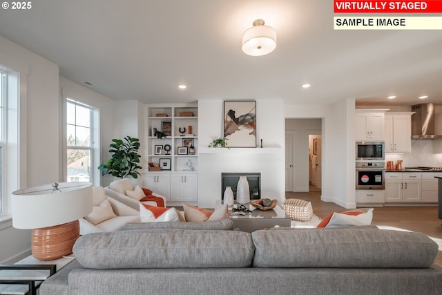 22987 Bland Cir, West Linn, OR 97068 - living room featuring a glass covered fireplace, light wood-style flooring, recessed lighting, and baseboards