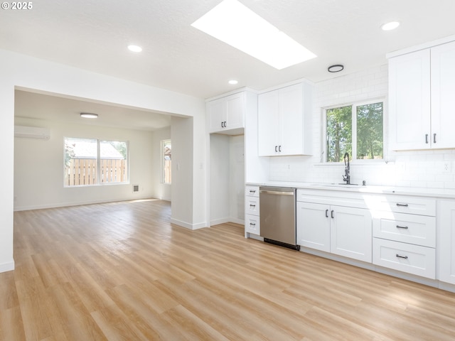 13928 SE Rhone St, Portland, OR 97236 - kitchen with stainless steel dishwasher, a sink, a wall mounted air conditioner, light wood-style flooring, and light countertops
