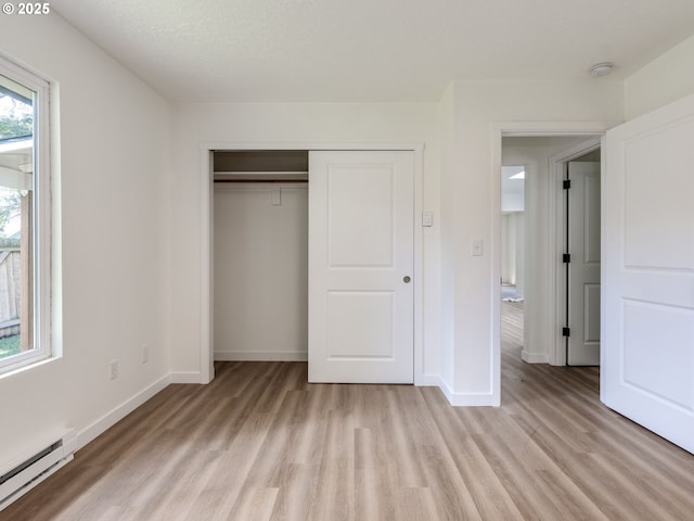 13928 SE Rhone St, Portland, OR 97236 - unfurnished bedroom with a baseboard heating unit, light wood finished floors, and baseboards
