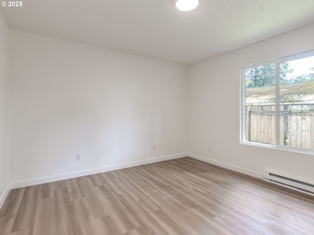 13928 SE Rhone St, Portland, OR 97236 - empty room with light wood-type flooring, a baseboard radiator, and baseboards
