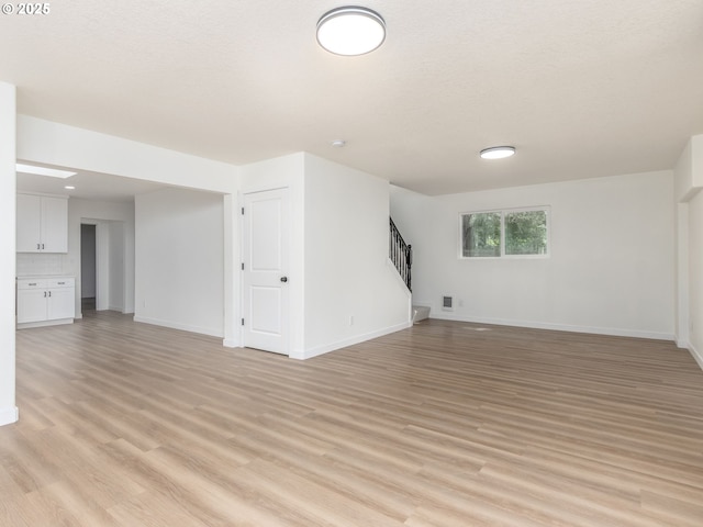 13928 SE Rhone St, Portland, OR 97236 - basement with stairs, light wood-type flooring, and baseboards