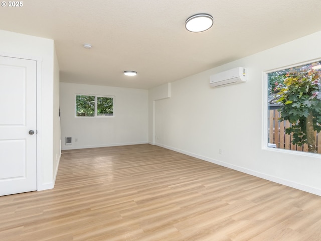 13928 SE Rhone St, Portland, OR 97236 - spare room featuring a wall mounted air conditioner, light wood-type flooring, baseboards, and a smoke detector