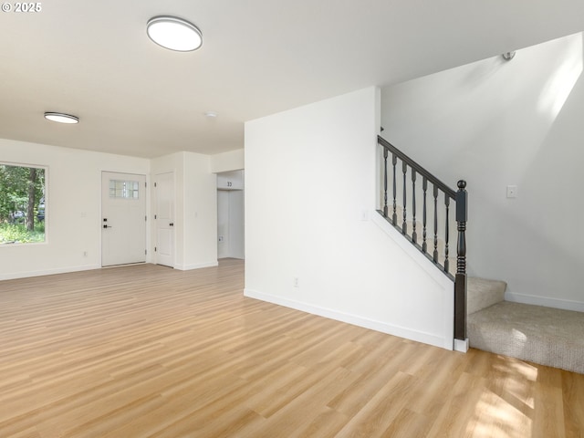 13928 SE Rhone St, Portland, OR 97236 - unfurnished living room featuring light wood-style floors, baseboards, and stairs