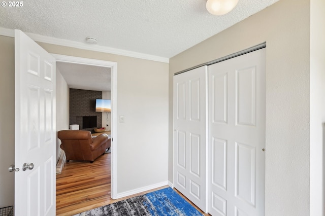 hall featuring wood finished floors, a textured ceiling, and baseboards