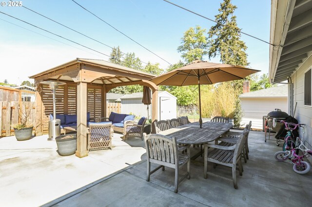 view of patio / terrace featuring an outdoor hangout area, a storage shed, fence, and a gazebo