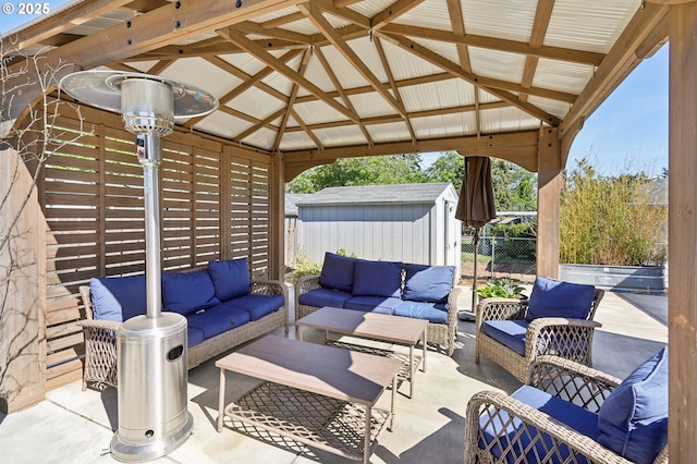 view of patio featuring outdoor lounge area, a storage shed, fence, a gazebo, and an outdoor structure