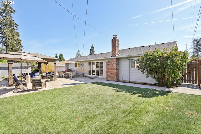 rear view of house with a chimney, a patio, and a shingled roof