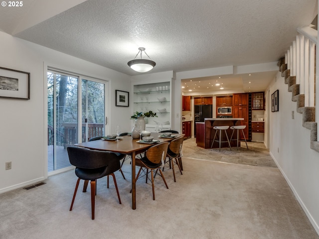 carpeted dining room featuring a textured ceiling