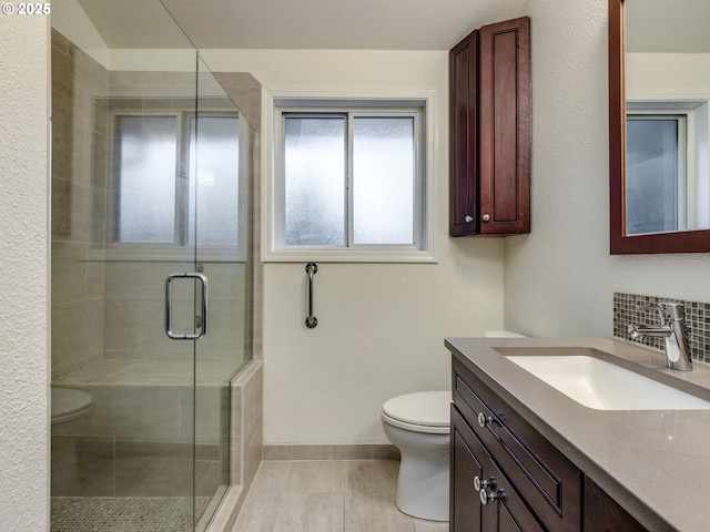 bathroom featuring tile patterned floors, vanity, toilet, and a shower with door