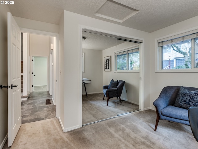 sitting room with light colored carpet and a textured ceiling