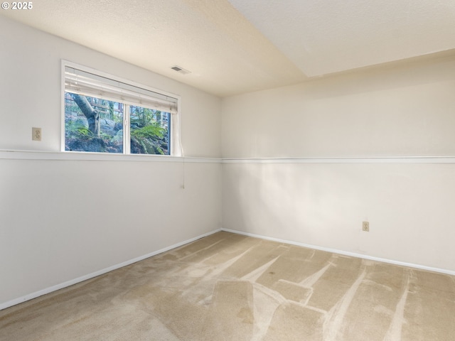 carpeted spare room with a textured ceiling