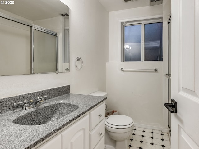 bathroom featuring a shower with door, vanity, and toilet